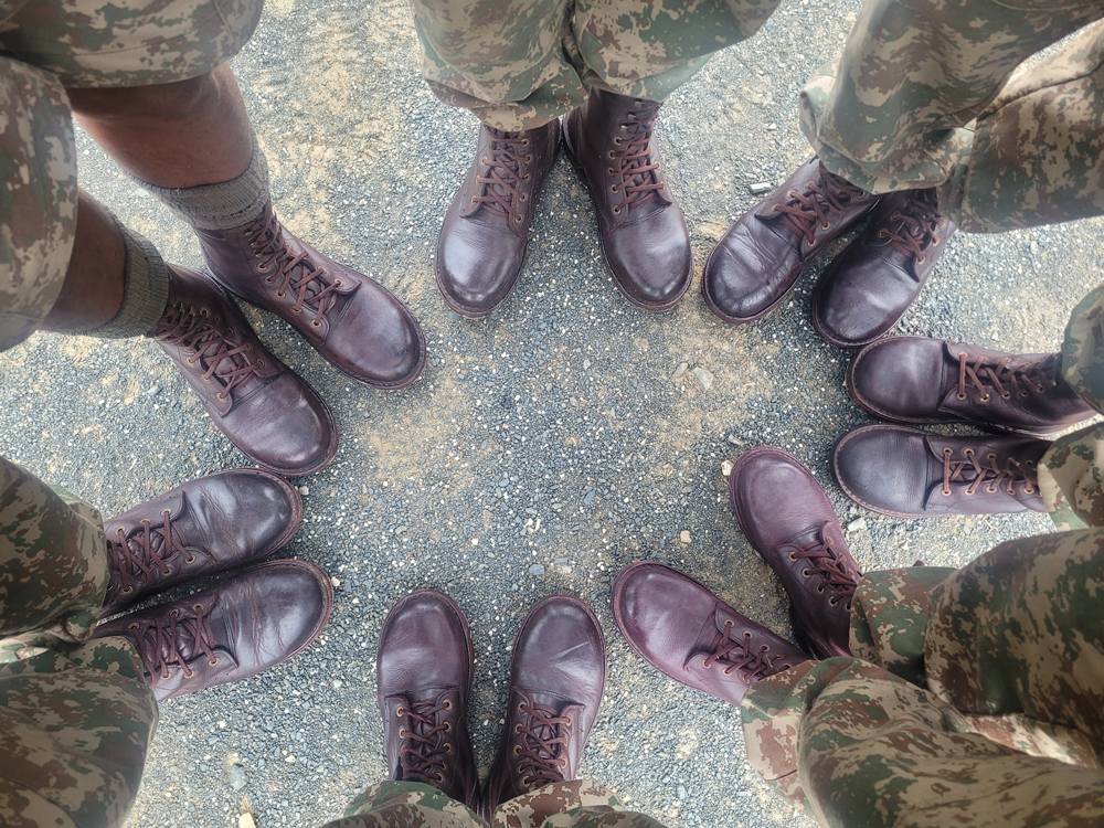 A top-down view of rangers' feet standing in a circle wearing Jim Green boots